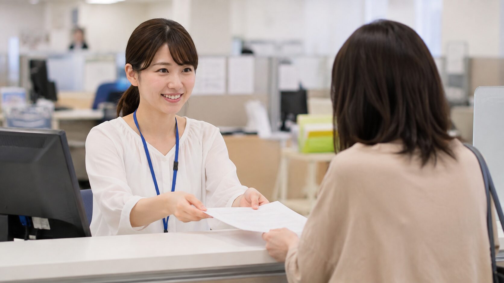 市役所の窓口で申請書類を受け取る様子